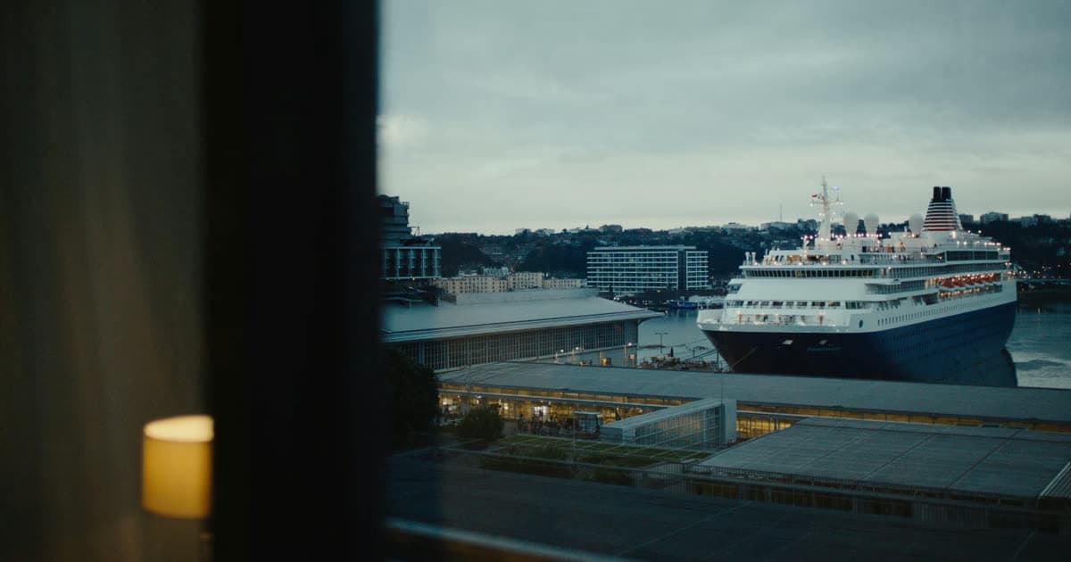 A hotel near a lit cruise terminal at dusk