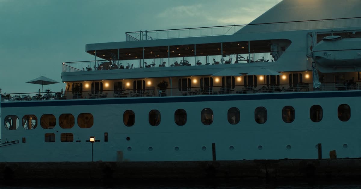 A Norwegian Cruise Line style ship at sea with an open promenade deck
