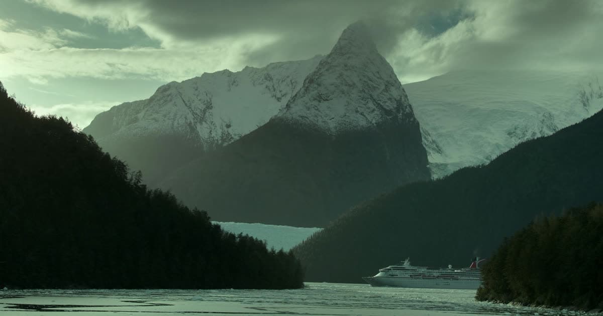 A cruise ship in a Patagonian channel below glaciated peaks