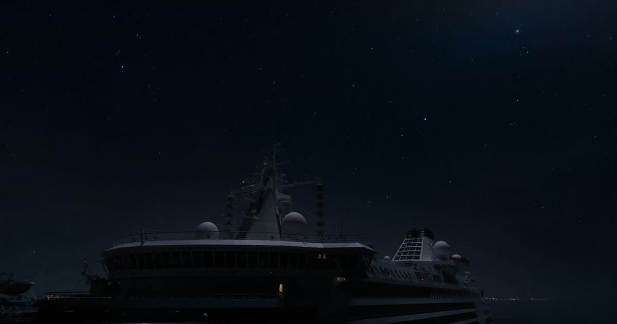 A cruise ship at sea beneath a satellite constellation