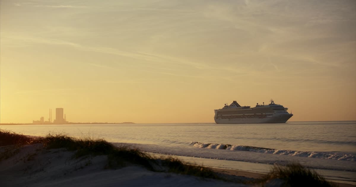 Cruise ships at a Florida Space Coast terminal with a launch gantry in the distance