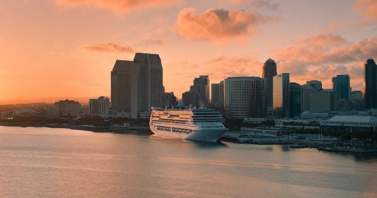 A cruise ship at a downtown San Diego pier with the bay and skyline behind