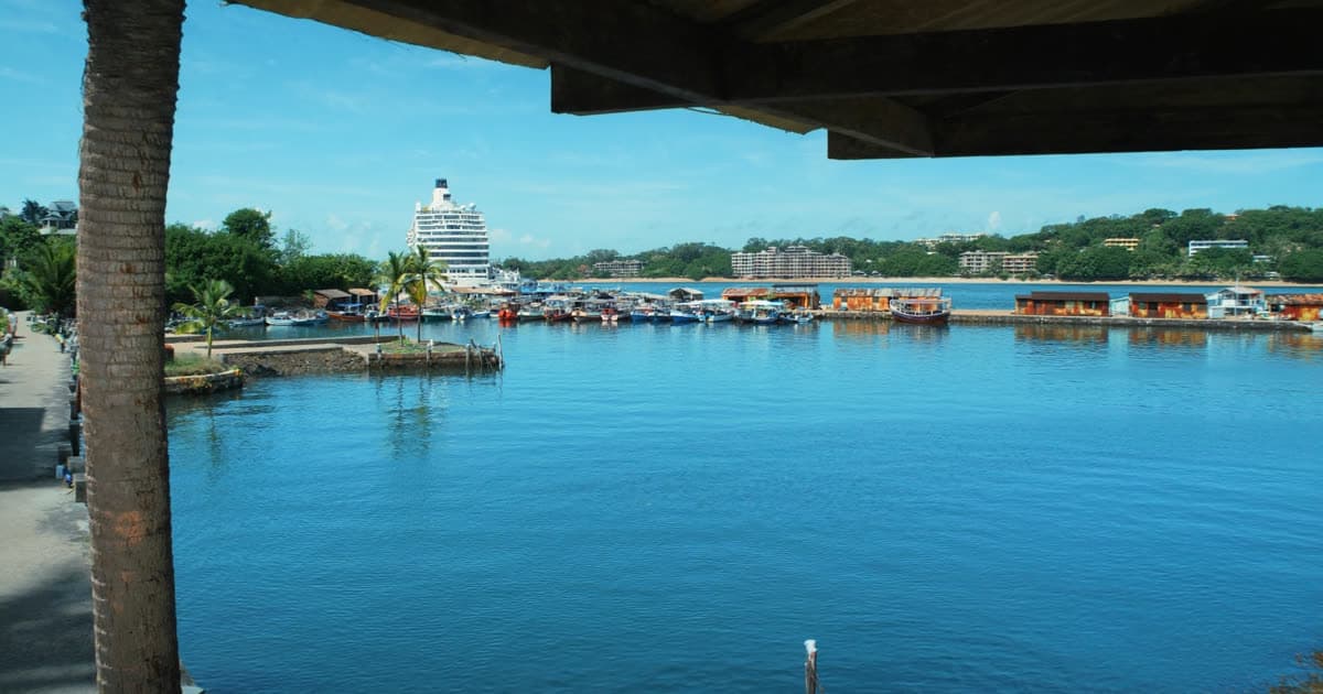 Tour boats, a railway and a beach beside a cruise port
