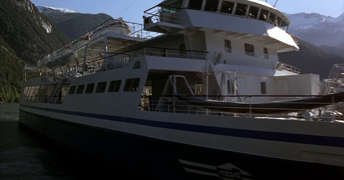 A Princess Cruises style ship in Alaskan waters beneath coastal mountains
