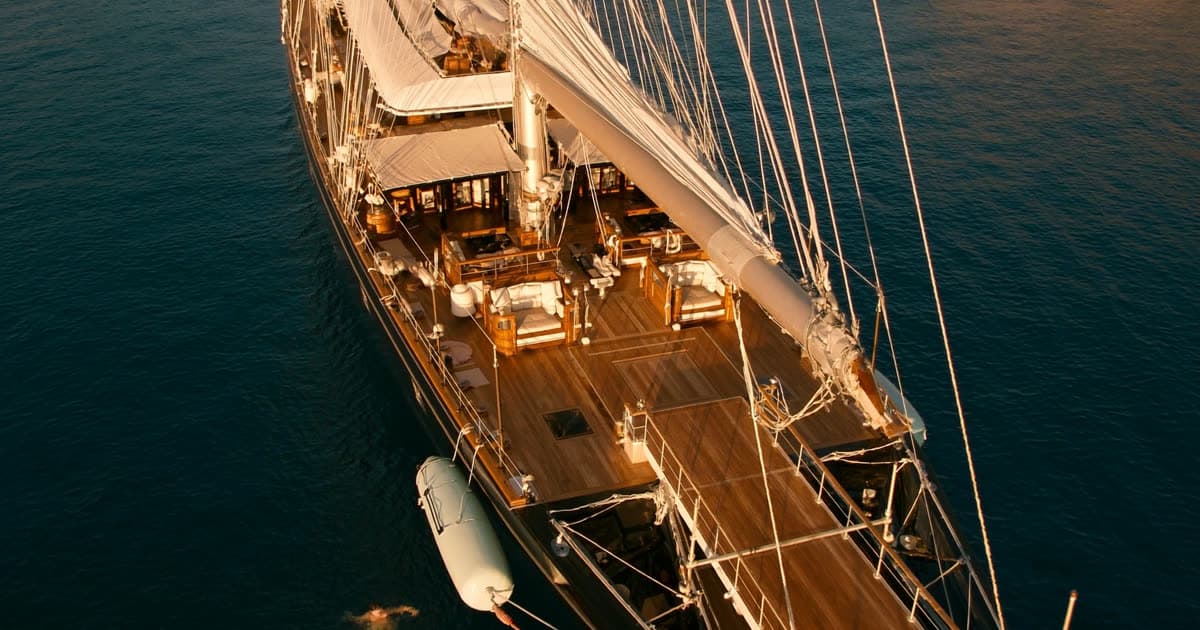 A small luxury ship at anchor in golden evening light